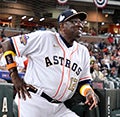 Dusty Baker in an Astros jersey standing in the dugout.