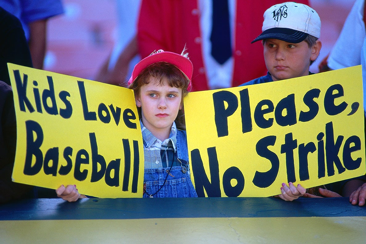 Children holding signs protesting a baseball strike