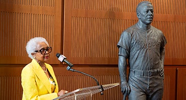 Billye Aaron speaks in front of Hank Aaron statue