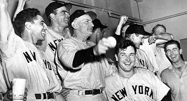 Casey Stengel celebrates with players in Yankees clubhouse