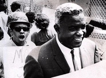 Jackie Robinson marches with sign