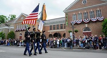 Color Guard marches with flags down Main Street