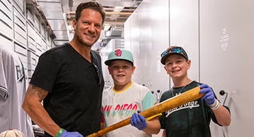 Jake Peavy and sons hold bat in Museum Archives
