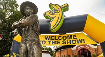 Sandlot Kid statue and Savannah Bananas balloon arch at Doubleday Field