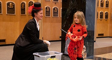 Museum professional shares candy with costumed child