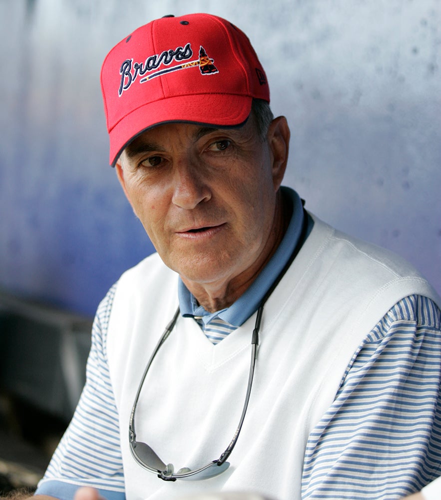 John Schuerholz in dugout wearing Braves cap