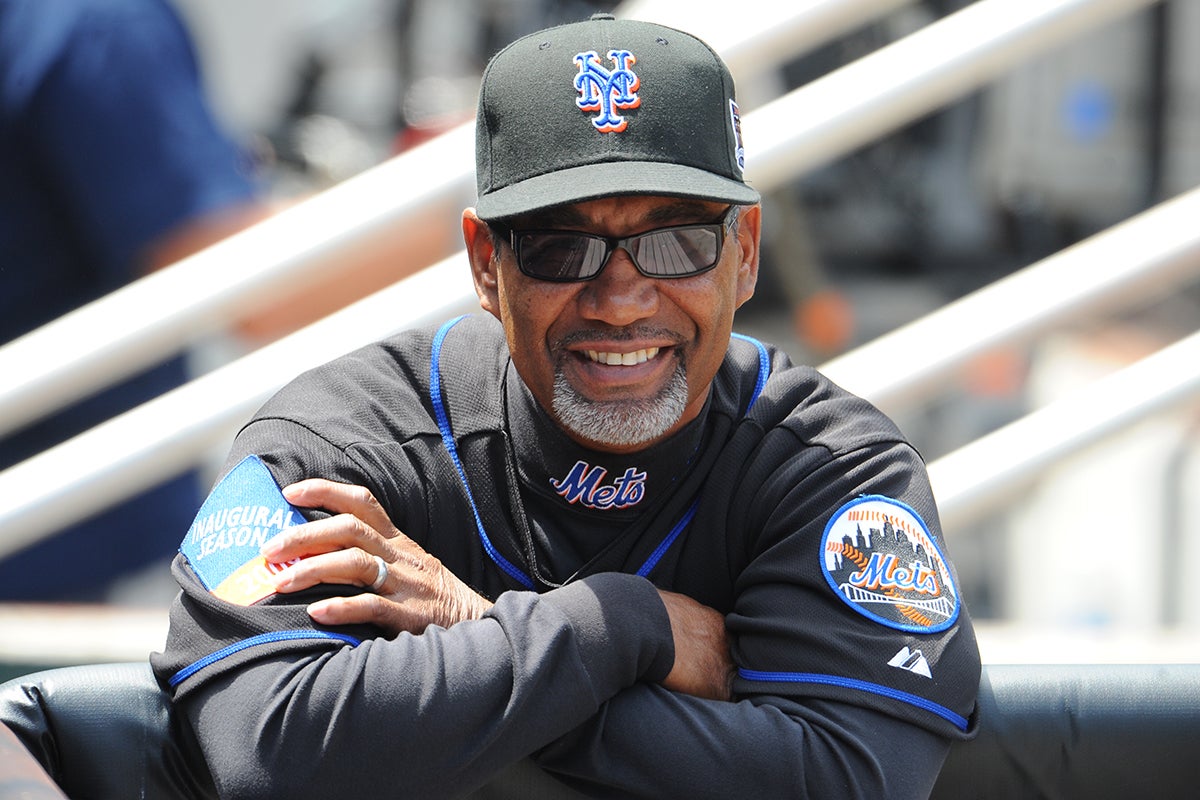 Jerry Manuel on dugout rail wearing Mets uniform