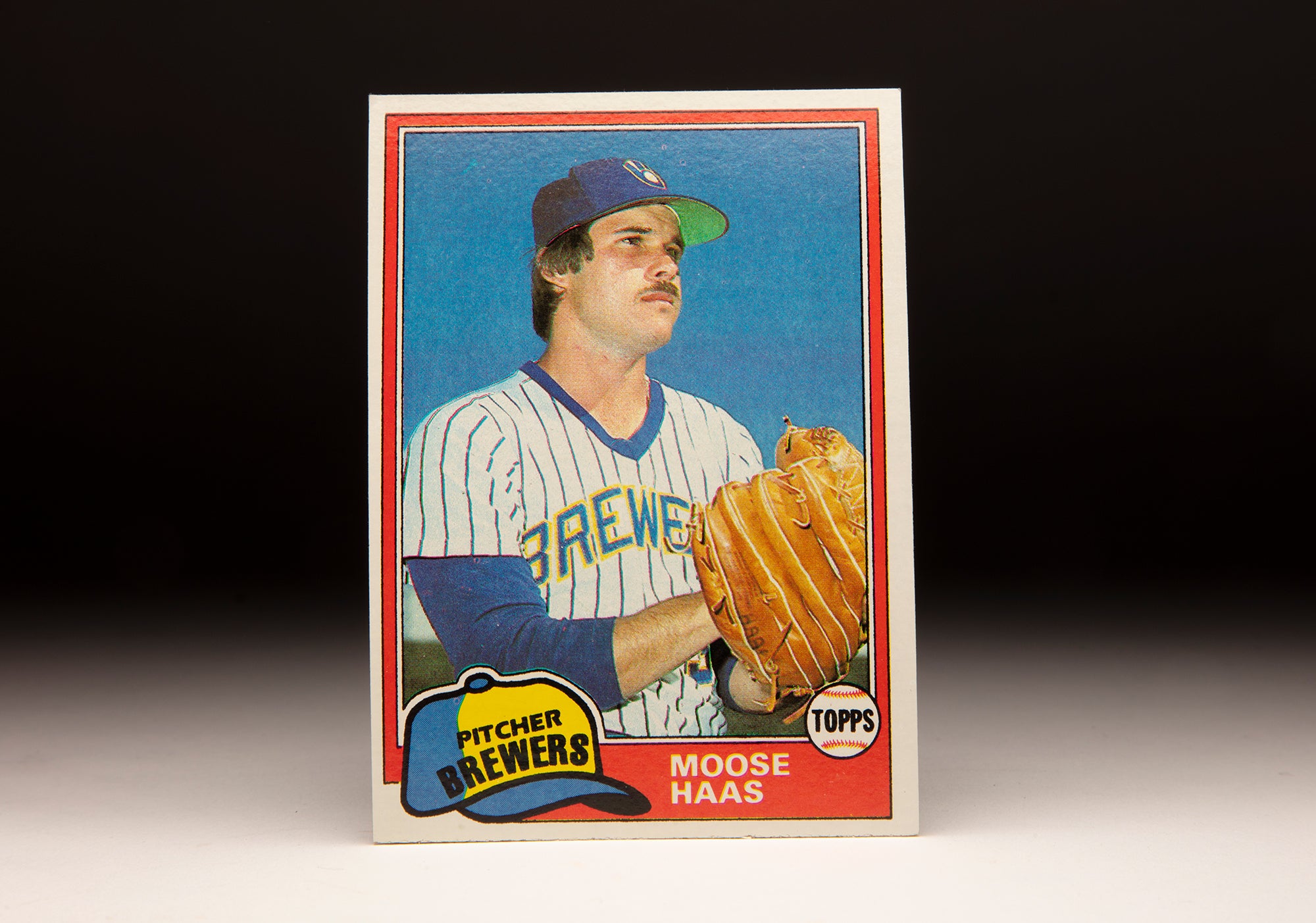 Front of 1981 Topps Moose Haas baseball card. He is wearing a white home jersey with blue pinstripes and blue letters with yellow trim.