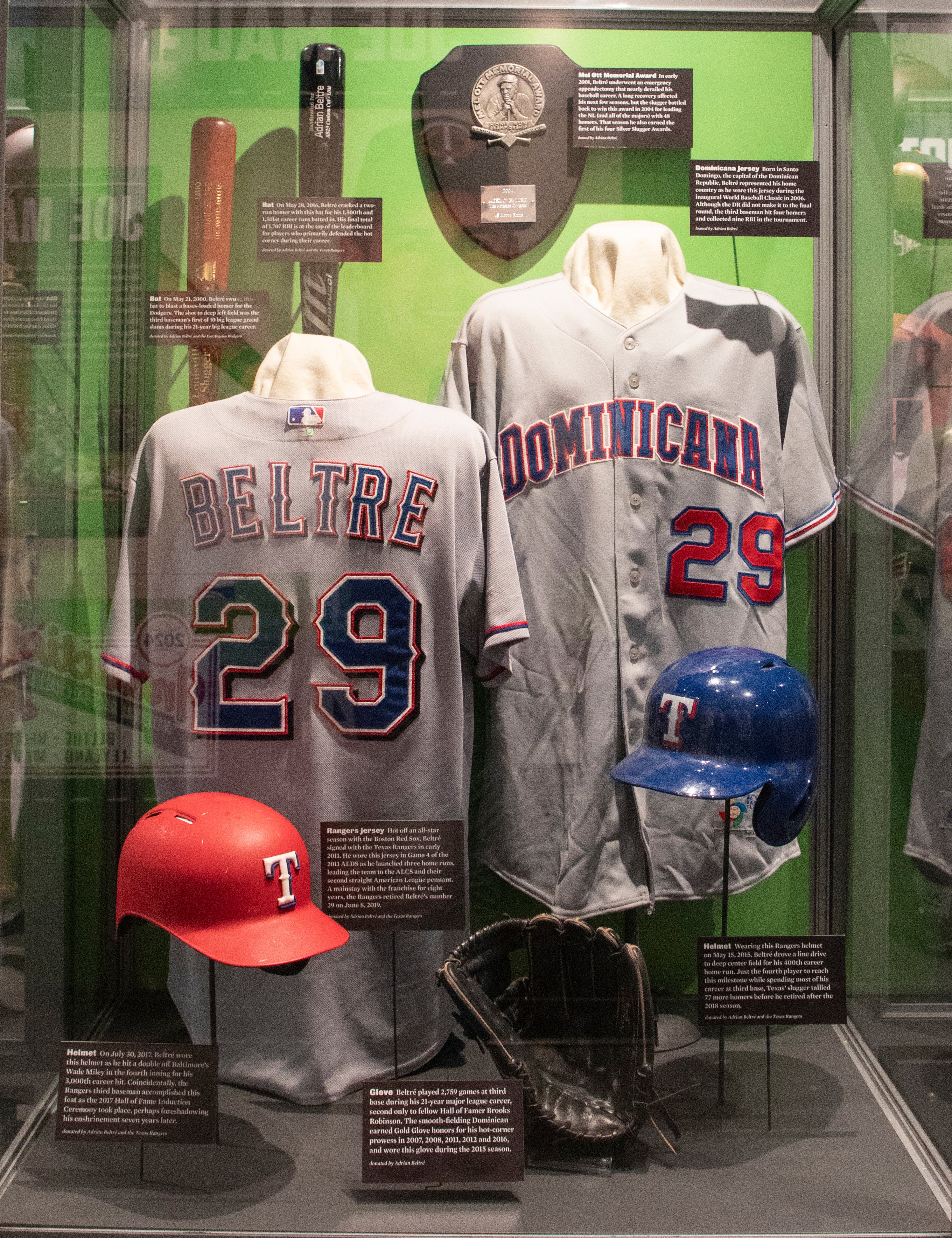 Adrian Beltre new inductee case with two bats, a Rangers jersey, two Rangers batting helmets, a Domincan Republic jersey from the WBC, a baseball glove and the Mel Ott award