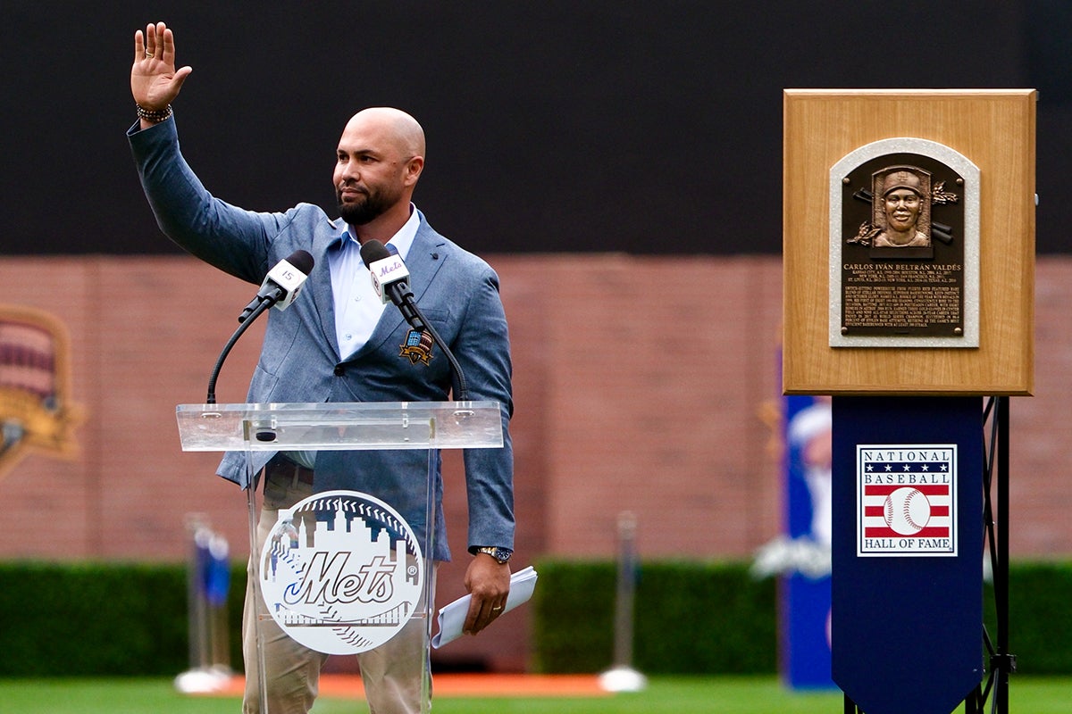 Carlos Beltrán stands next to Hall of Fame plaque