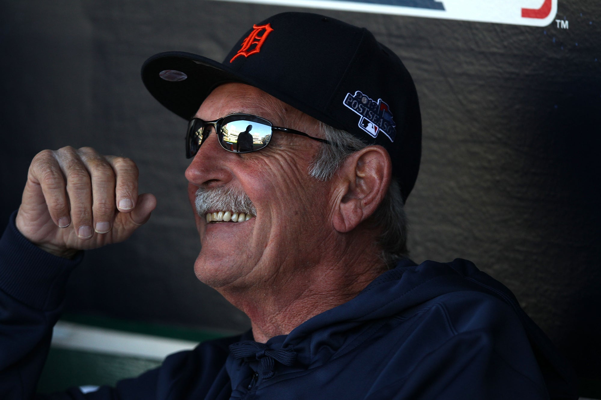 Jim Leyland smiling in dugout wearing Tigers cap.