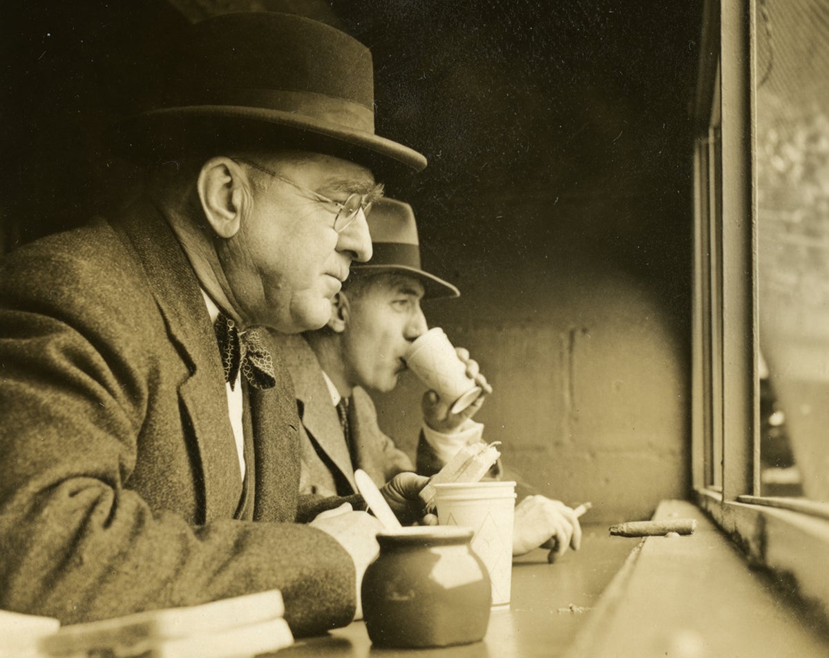 Branch Rickey watching game in suit and hat