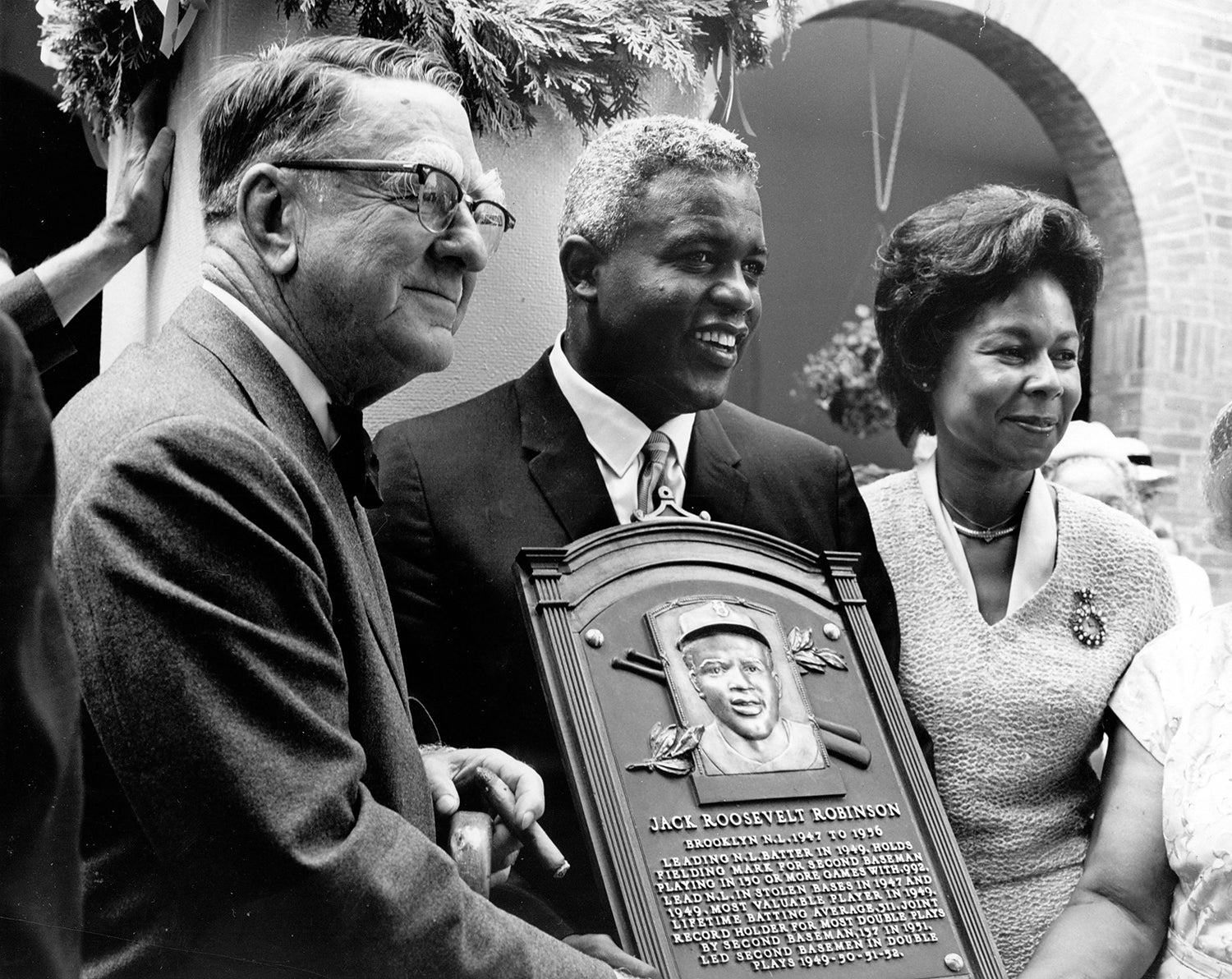 Branch Rickey and Rachel Robinson standing alongside Jackie Robinson after his Hall of Fame induction ceremony.