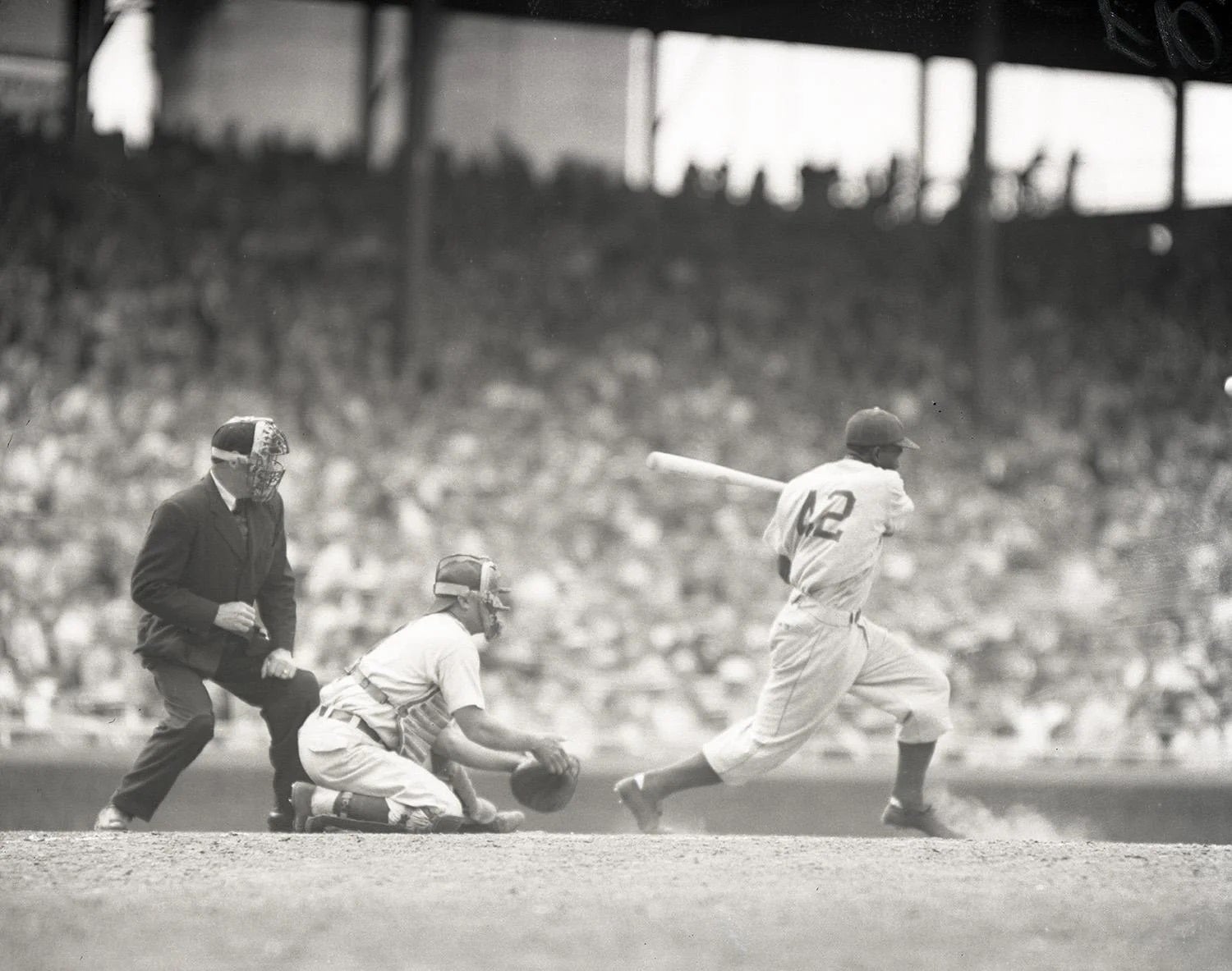 Jackie Robinson batting, catcher and homeplate umpire are also pictured