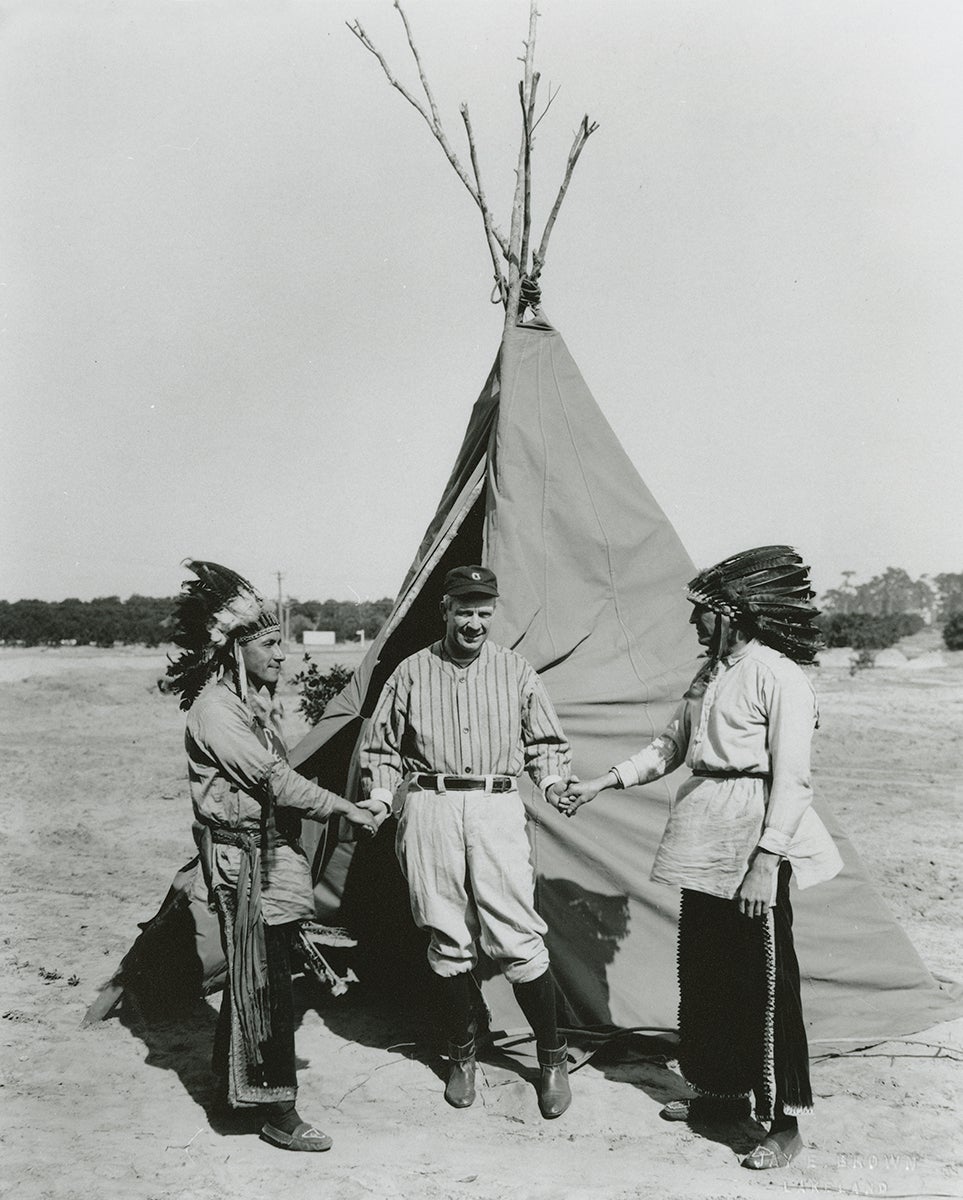 Tris Speaker shakes hands with two Native American men