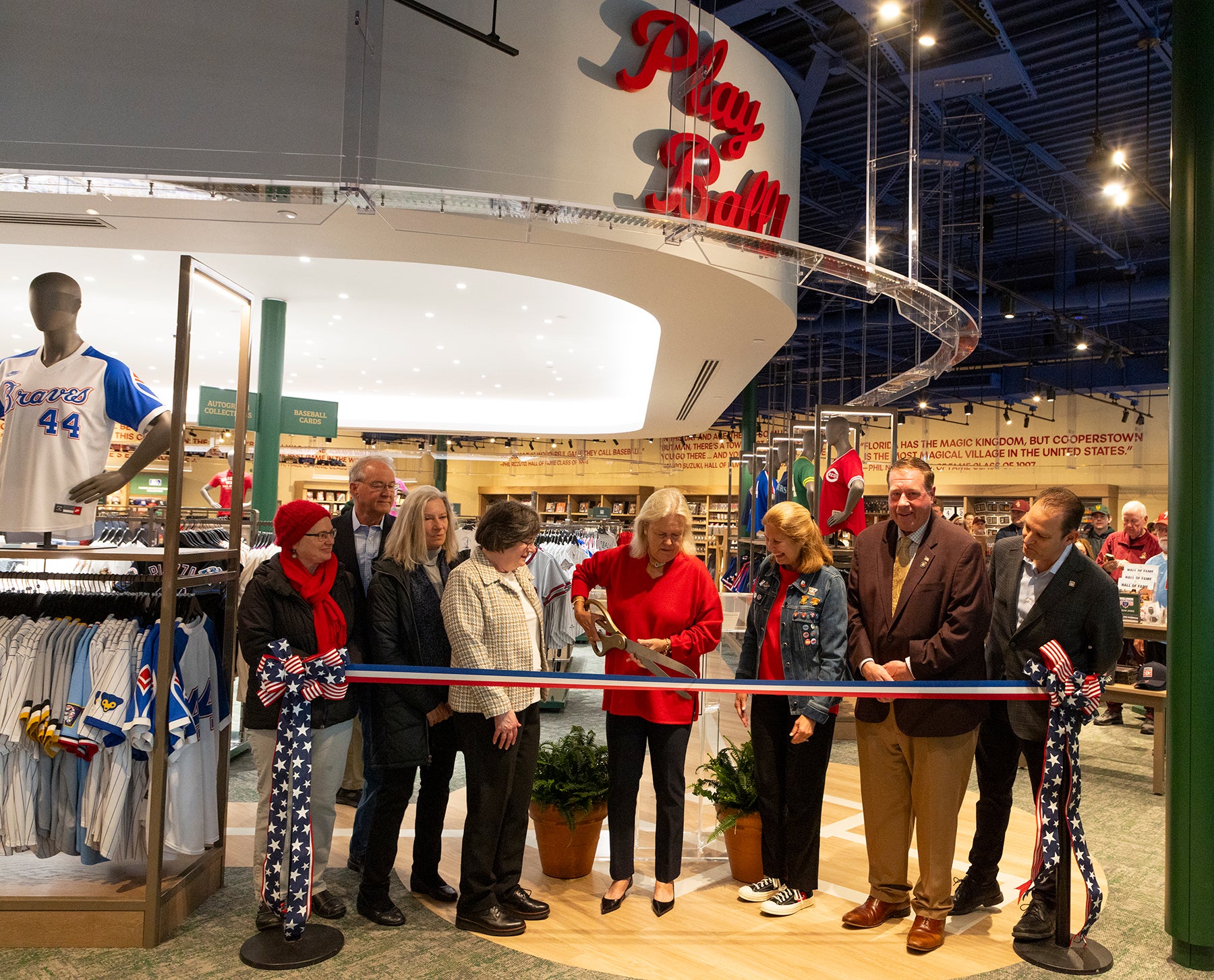 Group of dignitaries cuts red, white and blue ribbon at Museum Store