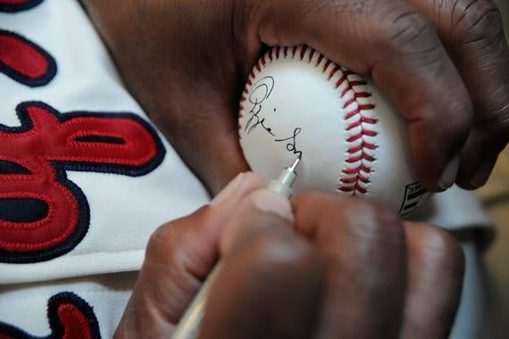 Hall of Famer Ozzie Smith signs a baseball during the 14th annual PLAY Ball fundraiser Friday at the Clark Sports Center in Cooperstown. (Milo Stewart, Jr. / National Baseball Hall of Fame)