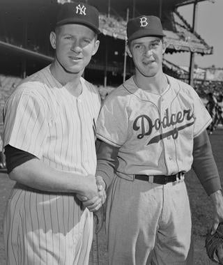 Whitey Ford, left, and Karl Spooner, starting pitchers for Game 6 of the 1955 World Series, shake hands before their matchup at Yankee Stadium on Oct. 3, 1955. (Osvaldo Salas/National Baseball Hall of Fame and Museum)