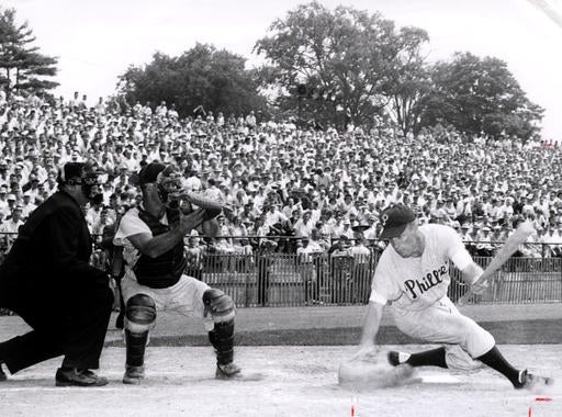 Future Hall of Famer Richie Ashburn takes a hard swing at Jim Constable's pitch. The catcher is Clint Courtney and  the umpire is Stan Landes. (National Baseball Hall of Fame Library)