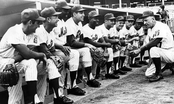 Casey Stengel talks to his Opening Day lineup on April 12, 1965. From left to right:  Billy Cowan, Roy McMillan, Johnny Lewis, Ed Kranepool, Joe Christopher, Charley Smith, Bobby Klaus, Chris Cannizzaro and Al Jackson. (National Baseball Hall of Fame) 