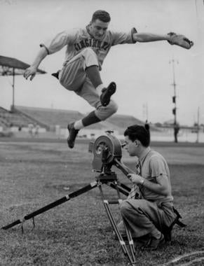 Reds first baseman Frank McCormick leaps over a camera set up on the field. BL-6552.70 (National Baseball Hall of Fame Library)