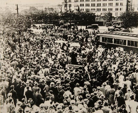A parade of American players in Tokyo stops all traffic and normal business as enthusiastic crowds swelled the sidewalks and streets of the city.  – B-277-51-11 (National Baseball Hall of Fame Library)